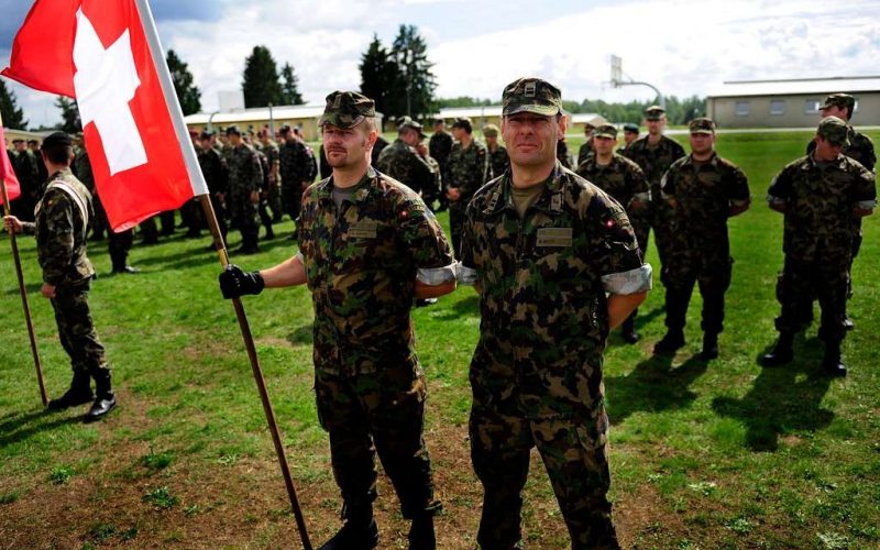 Die Schweiz verteidigt sich seit Jahrhunderten allein – mit einer Armee, die fast vollständig aus Wehrpflichtigen besteht und deren Bild zwischen Wehrhaftigkeit und Feierabenddienst schwankt. Seit dem russischen Angriff auf die Ukraine richtet sich die Truppe wieder auf die Landesverteidigung aus und trifft dabei auf drei Jahrzehnte Substanzverlust, Ausrüstungslücken und eine blockierte Finanzierung. Eine Bestandsaufnahme von Auftrag, Struktur, Material und den Grenzen des Milizmodells.